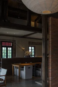 Cozy restaurant interior with wooden floors and walls, dining tables, chairs, and potted plants