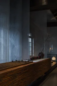 A cozy dining area with a wooden bar counter, wine glasses, and scattered cups, creating a warm atmosphere for socializing and enjoying drinks