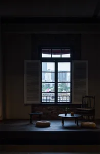 Cozy living space with natural light, a chair, two couches, and a dining table, overlooking a city street