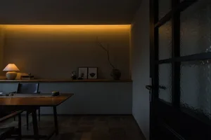 A cozy dining area with a wooden table and chairs, a vase, and a warm atmosphere