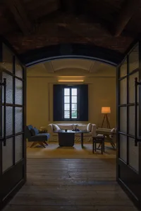 Cozy open living space with natural light, two couches, chairs, a dining table, and a potted plant