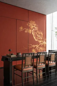 Dining area with red walls, a wooden table, and four chairs, featuring a vase and warm lighting