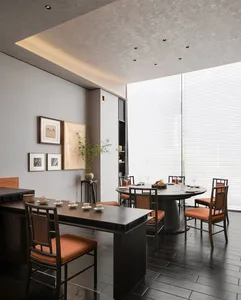 Elegant dining space with a large wooden dining table and chairs, wine glasses, and a sophisticated atmosphere