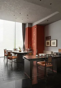 A dining area with a large wooden table and chairs, wine glasses, and an elegant atmosphere