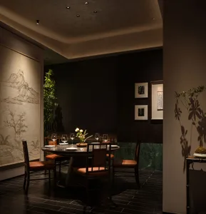 Sophisticated dining area with a large wooden table surrounded by chairs, wine glasses, and cups, set in a restaurant environment