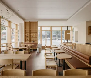 Modern restaurant interior with wooden tables and chairs, giving a warm and inviting atmosphere