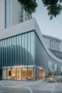 Modern building with a curved glass front facade, a prominent sign, and natural light