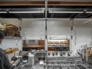 Industrial kitchen with various appliances, bowls, and bottles, creating a functional space for food preparation