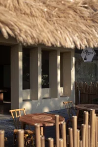 Warm dining space with bamboo elements, a wooden table, and benches in a cozy atmosphere