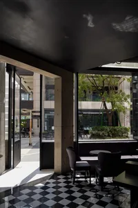 Modern restaurant interior with tables, chairs, bar, potted plants, artwork, and modern design