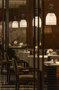 Dining area with white tablecloths, chairs, and a sophisticated ambiance