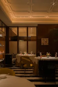 Sophisticated dining space with a large wooden table, chairs, and decorative elements like potted plants