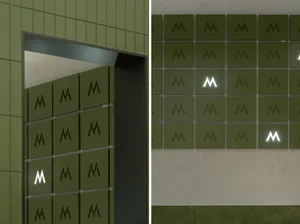 A green wall with M's in two different configurations, one with four and one with six, on a concrete surface
