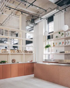 A warm and inviting kitchen with wooden cabinets and countertops, featuring a sink area, dining table, and potted plants