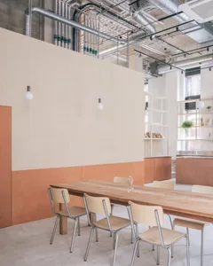 Open kitchen area with wooden floors and walls, featuring a dining table and chairs, a sink, and modern cabinets