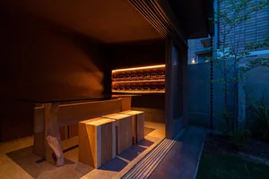 Dimly lit kitchen with wooden cabinets and countertops, wine bottles, and a warm ambiance