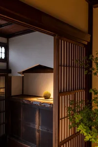 Cozy Asian-style living area with wooden walls, a small table, and a bowl, creating a warm and inviting atmosphere