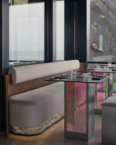 Elegant dining space with wooden tables, wine glasses, cups, and bowls, set for dinner service