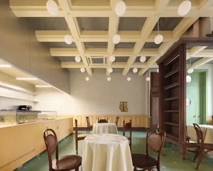 A dining area with a large table and chairs, a white tablecloth, and a cozy atmosphere
