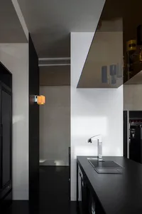 Modern kitchen with two sinks, a black countertop, and white cabinets