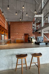 Cozy restaurant interior with a brick wall, bar area, and dining table with chairs