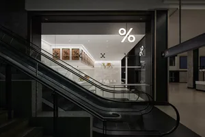 Bright and welcoming commercial space with a modern design, featuring a large glass wall, staircase, and ample natural light