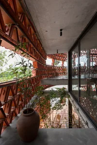 Spacious interior space with red brick walls, a staircase, chairs, and potted plants