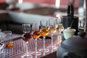 A bar area with five wine glasses on a countertop in front of a sink, creating an inviting atmosphere for patrons to enjoy their drinks