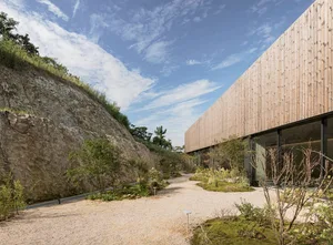 A modern building with a wooden exterior, a large glass wall, and a contemporary atmosphere