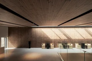 Open living area with wooden walls and ceiling, featuring a seating arrangement around a dining table and ample seating options