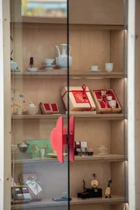 A display case filled with various items such as cups, bowls, vases, and boxes in different sizes and positions, creating an appealing and organized presentation