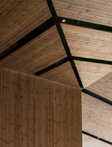 A modern space with exposed wooden beams and ceiling panels, creating a warm and inviting atmosphere with clean lines and simple shapes, well lit by natural sunlight