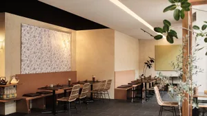 Warm and inviting restaurant interior with wooden tables and chairs, multiple dining areas, and a focus on comfort and functionality