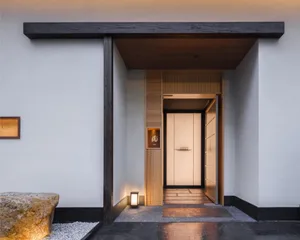 A warm and inviting entrance hallway with wooden walls, lit by two light fixtures, one near the left and one near the right side