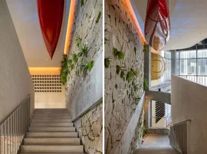 A rustic stone staircase with red and green canoes hung on the walls, adding a decorative element to the space, creating an inviting and comfortable atmosphere