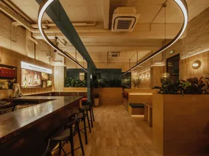 開放式概念現代餐廳，設有酒吧區、盆栽植物與溫馨氛圍