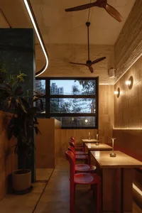 Warm and inviting restaurant interior with red chairs and multiple dining tables, providing ample seating options