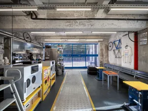 Industrial warehouse with open space, machines, benches, bicycles, and bottles, featuring a functional and utilitarian atmosphere