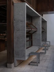 Industrial storage space with a concrete wall, a wooden door, and benches along the wall