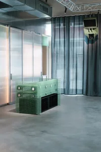 A modern dining space with a unique metal table and two chairs, surrounded by a minimalist atmosphere with a focus on functionality and simplicity