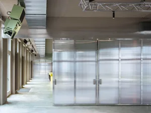 Empty industrial hallway with concrete walls and several doors on both sides