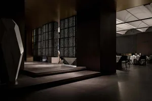 Empty black and white room with wood paneling walls, two large windows, and a warm atmosphere