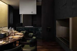 A sophisticated dining area with a large wooden table and chairs, wine glasses, and a warm atmosphere