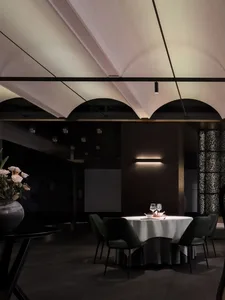 A sophisticated dining area with a table set for a meal, featuring wine glasses, plates, and cutlery, with a well-organized and inviting atmosphere