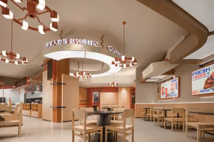 A restaurant interior with wooden tables and chairs, creating a cozy atmosphere for dining