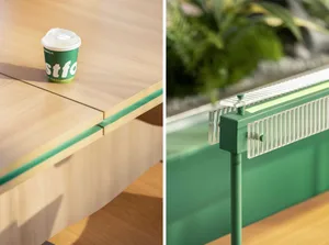 An office workspace with two desks, one green and one wooden, each with a cup and potted plants, creating an organized and inviting atmosphere