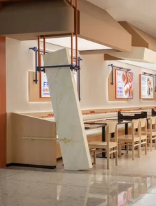 A restaurant interior with wooden tables and chairs, advertisements on the walls, and a clean and well-organized atmosphere