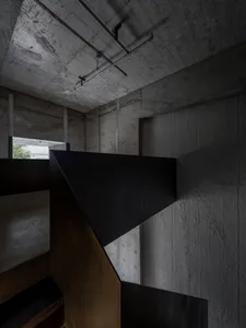 Black and white photo of a staircase with concrete steps, suggesting a historical or modern building with a timeless feel