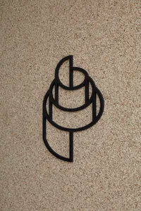 A modern interior space with a brick wall featuring a black metal sign in the shape of a stylized letter P