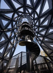 A rendered image of a spiral staircase with a black metal railing and surrounding structure, set against a blank background